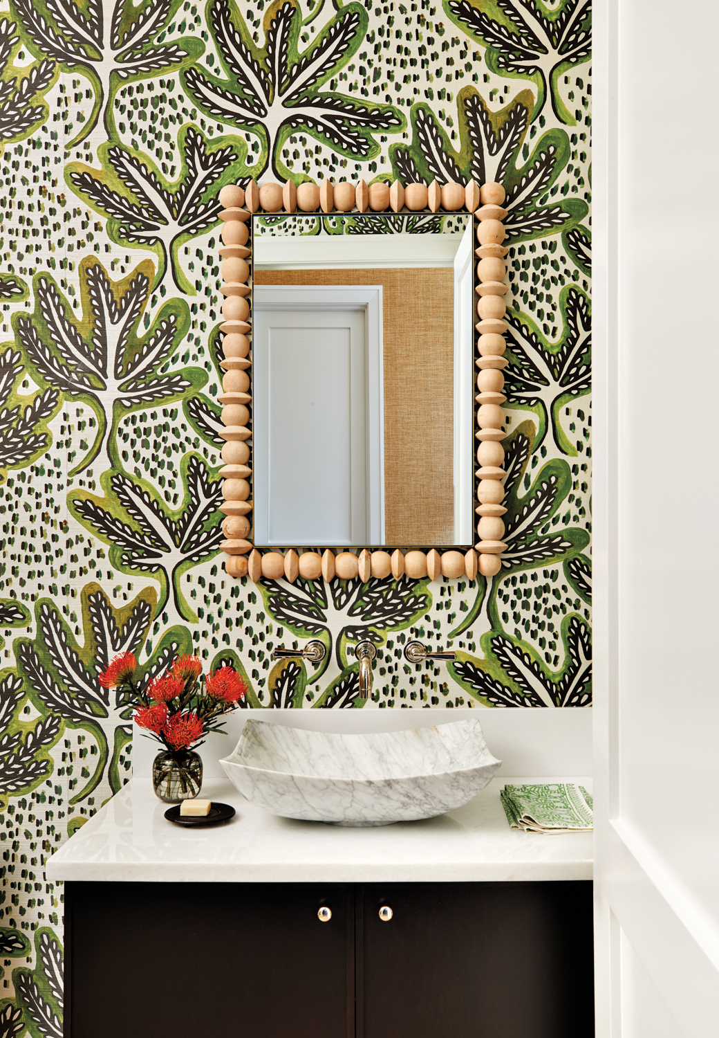 Powder room with green-patterned wallpaper,...