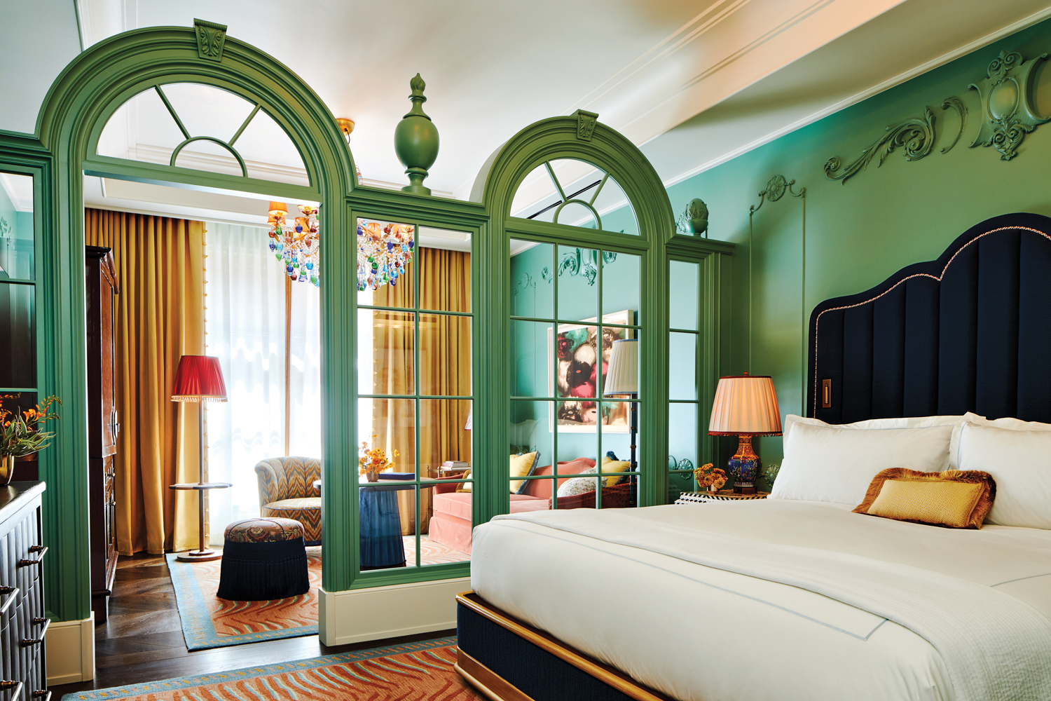 A hotel suite at Fifth Avenue Hotel, with green walls and Gilded Age-inspired decor and furniture.