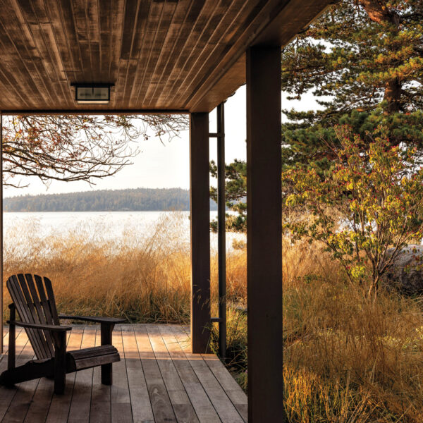An Adirondack chair sits on a deck with a view.