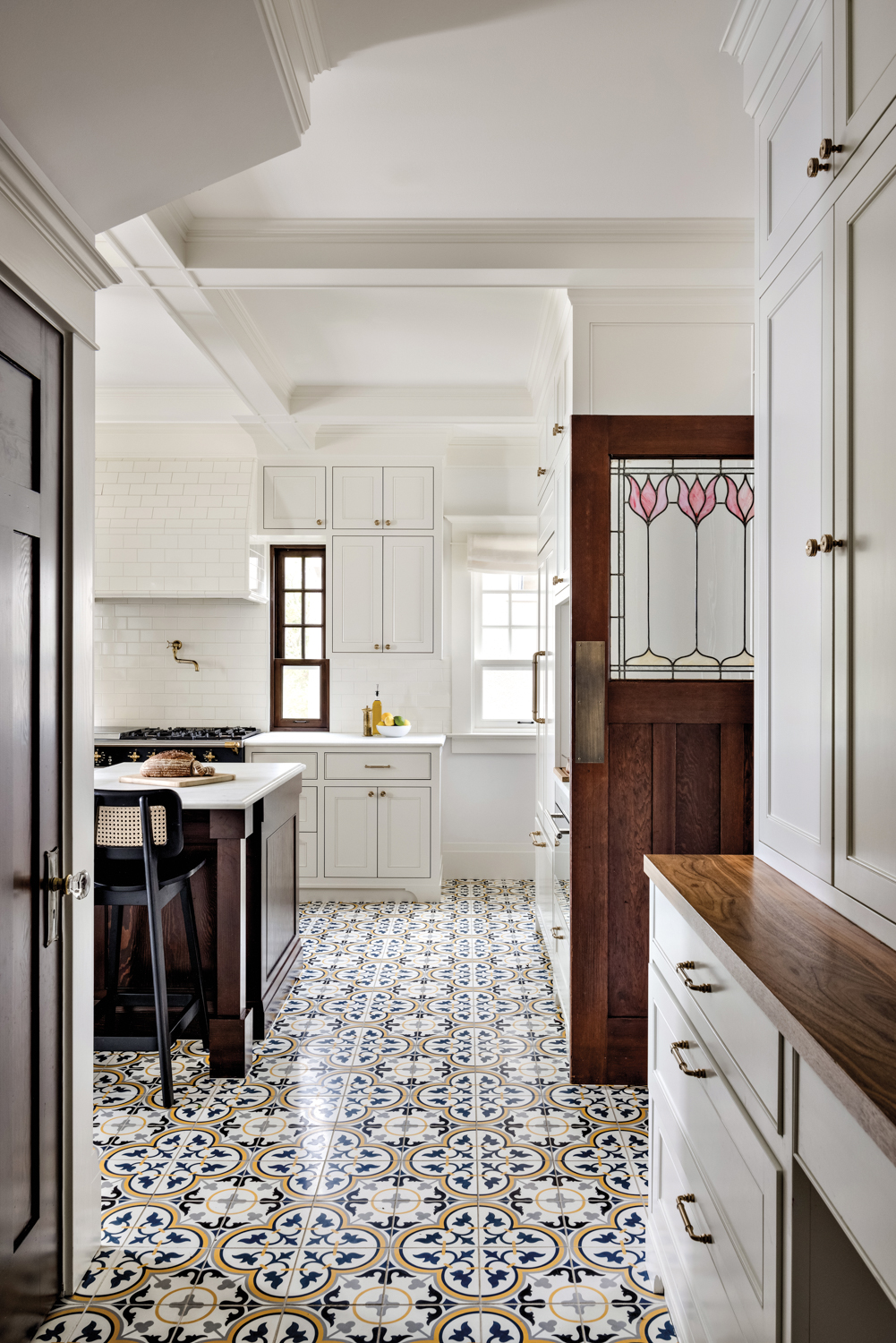 Kitchen with white cabinets, patterned...