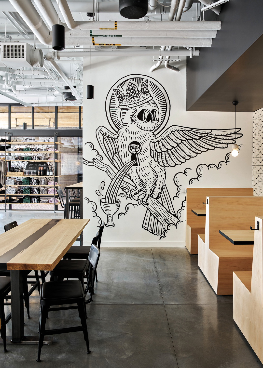 The taproom at Holy Mountain Brewing with a mural of a crowned bird pouring beer from its chest