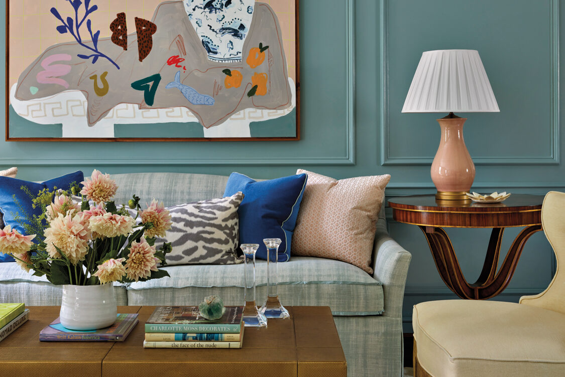 Living room with a cozy sofa, scalloped coffee table and an abstract still life painting