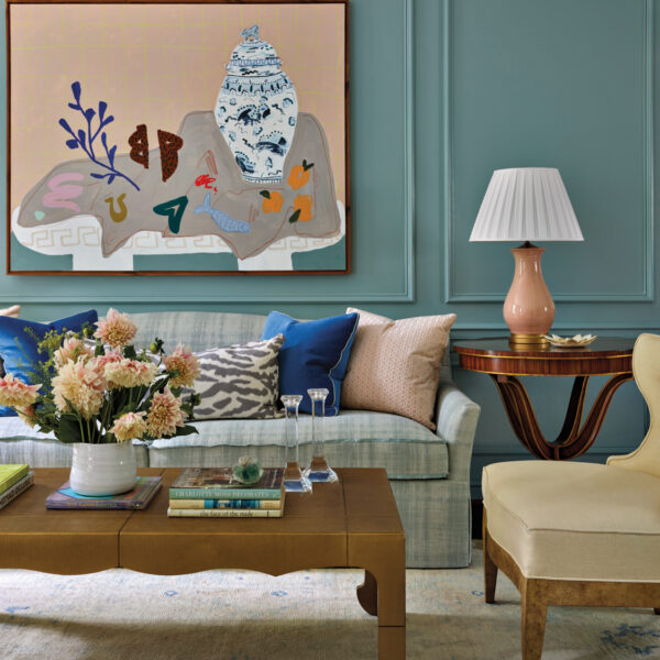 Living room with a cozy sofa, scalloped coffee table and an abstract still life painting