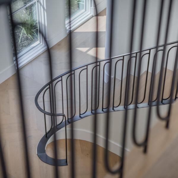 Staircase railing with intricate metal design, featuring swirls and curves for a decorative touch