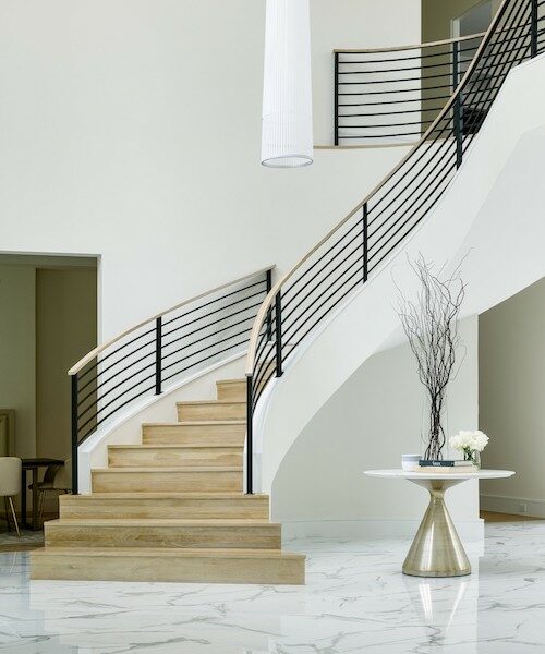 A grand foyer with a beautiful staircase, blending various elements to create a stunning entrance.