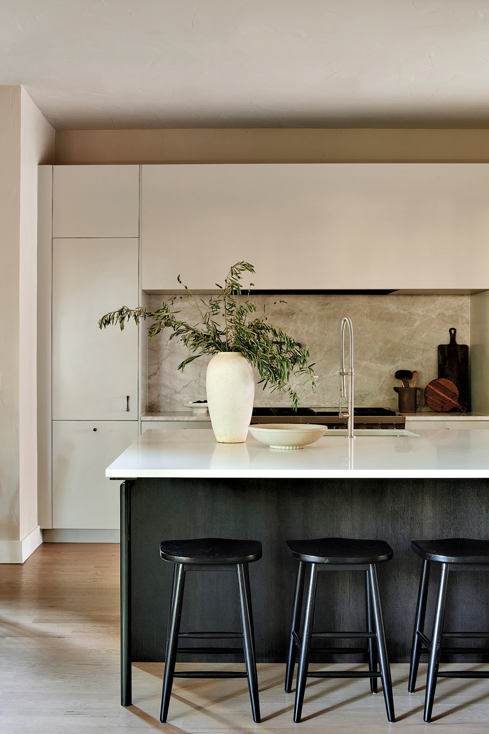 a kitchen island with black barstools