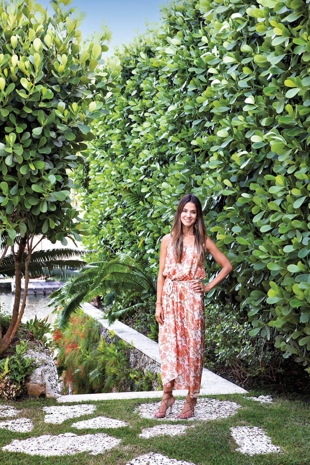 Carolina Freyre stands beside a towering shrub