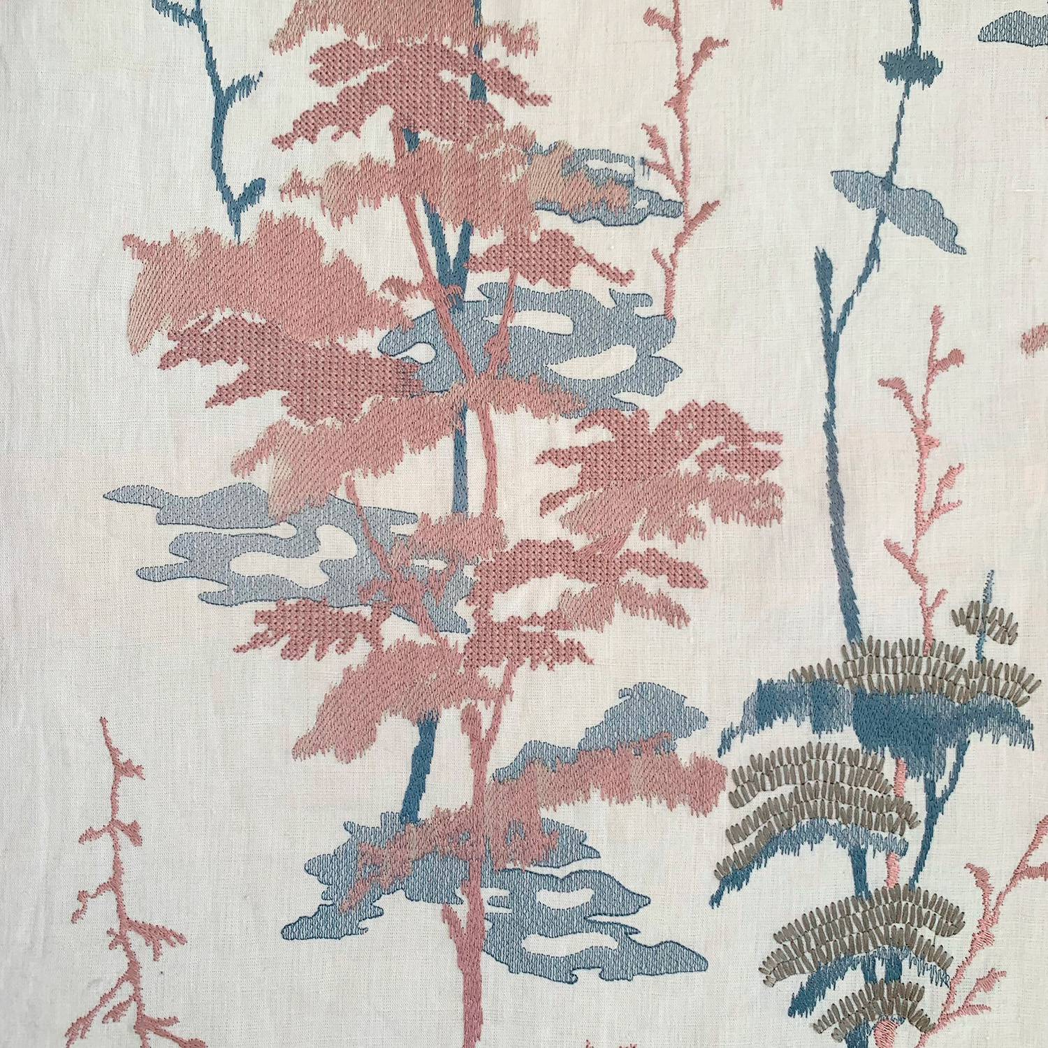Botanical print fabric in shades of red and blue against a cream background