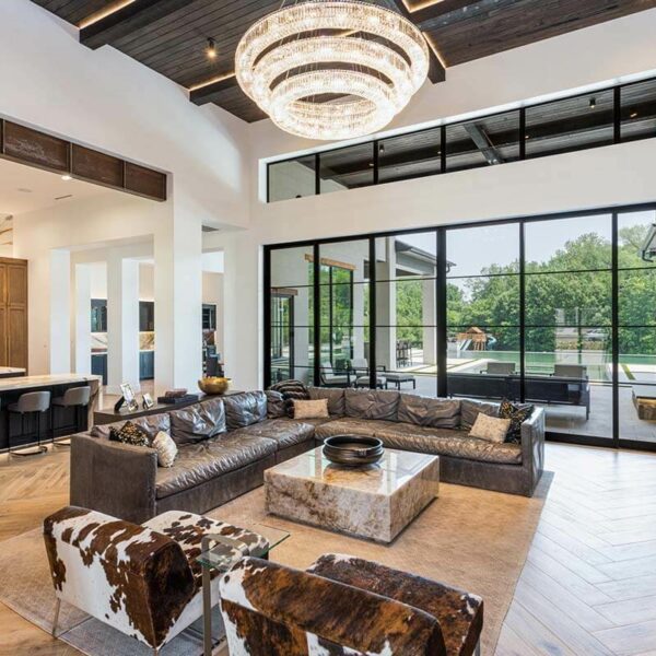 A living room with a large chandelier and a large glass sliding doors.