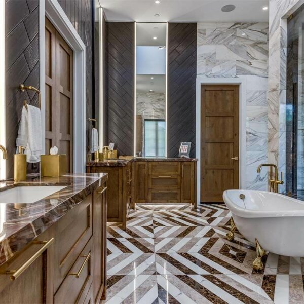 A bathroom with marble flooring and a tub.