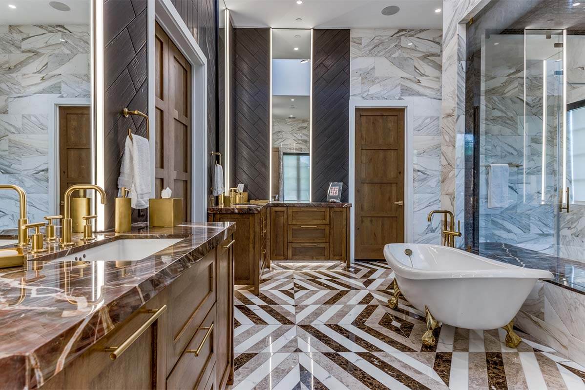 A bathroom with marble flooring and a tub.