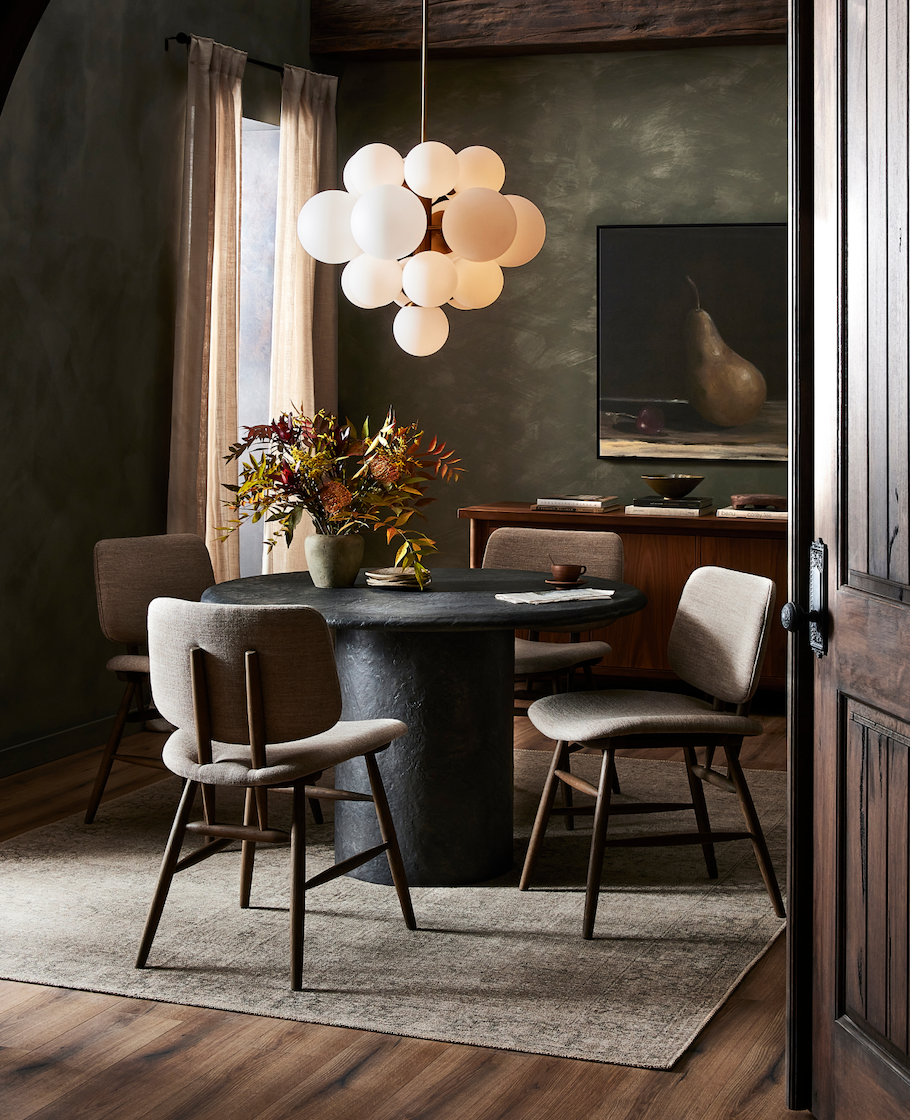 a dining room with a round table and chairs