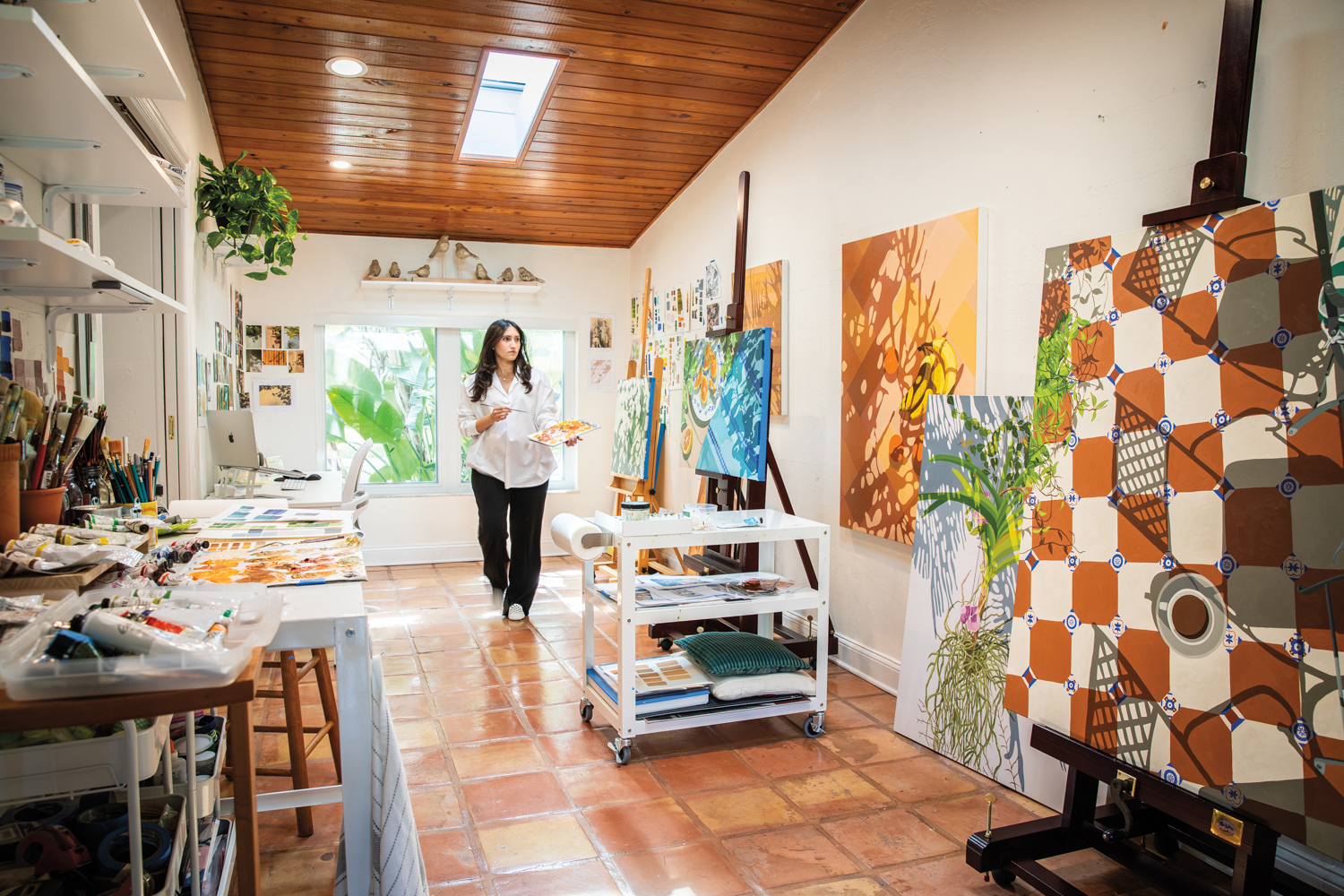 artist natalia juncadella walks towards her oil paintings in her home studio