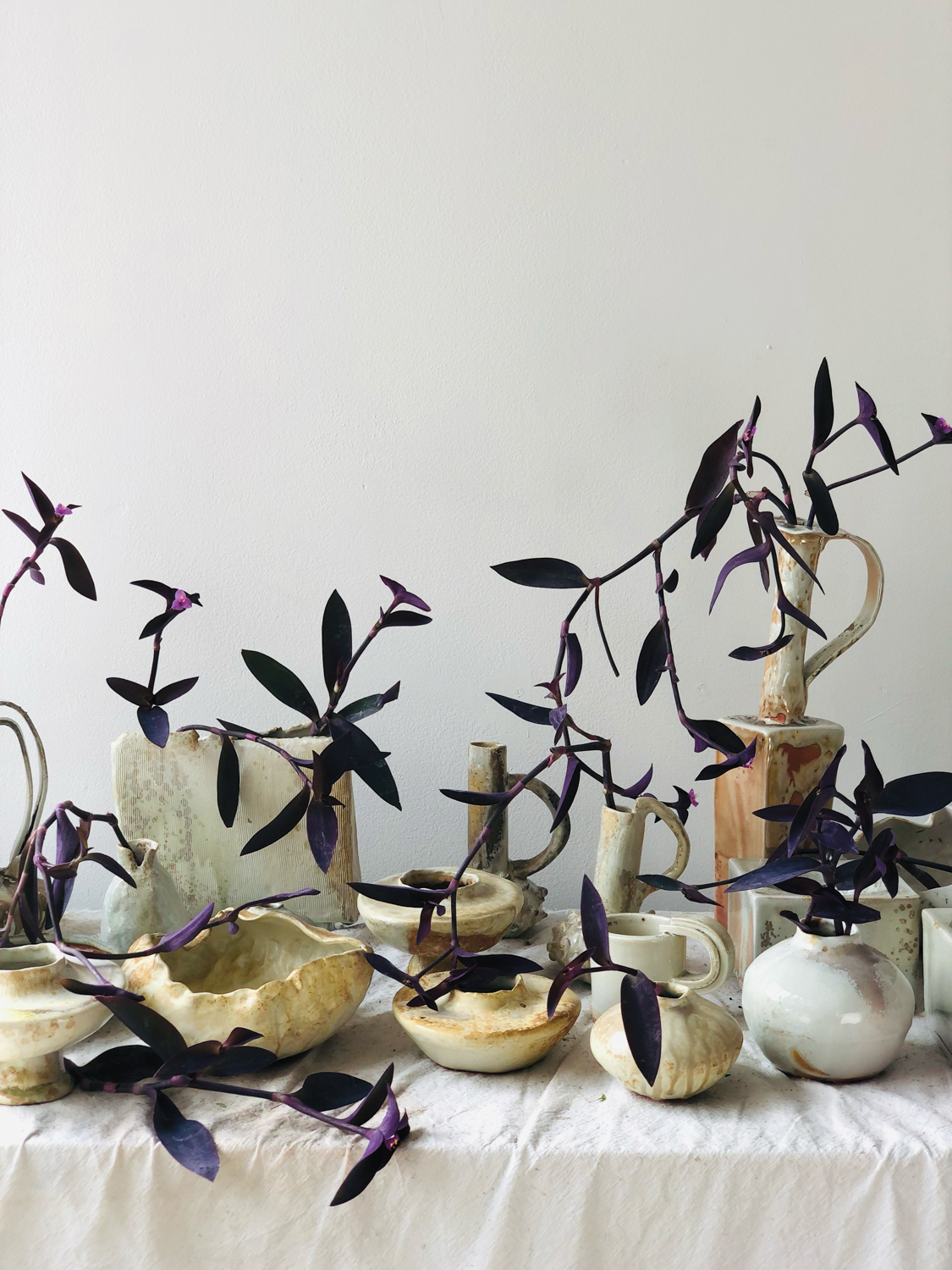 Floral installation with purple vines in white-ceramic pots