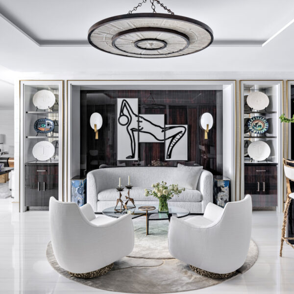 sophisticated home bar with round white rug, round chandelier, curvy sofas and armchairs