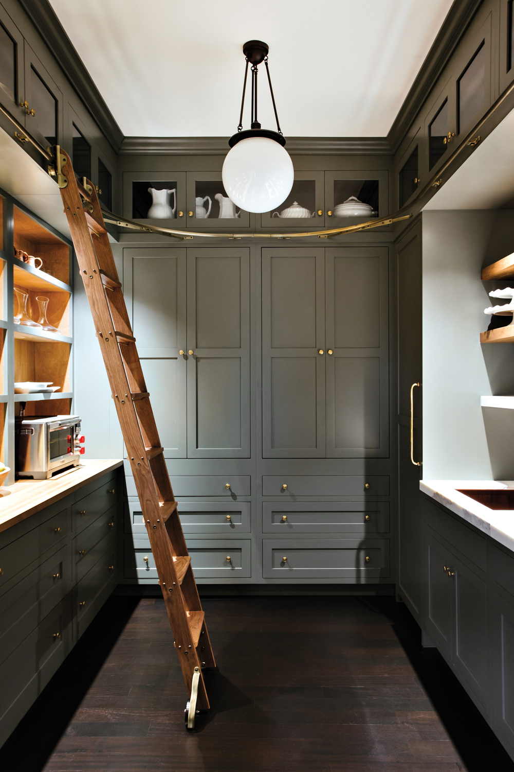 Green-gray pantry with rolling ladder,...