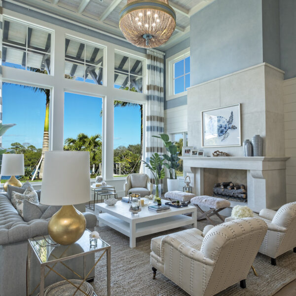 A spacious living room adorned with a luxurious chandelier and a plush couch.