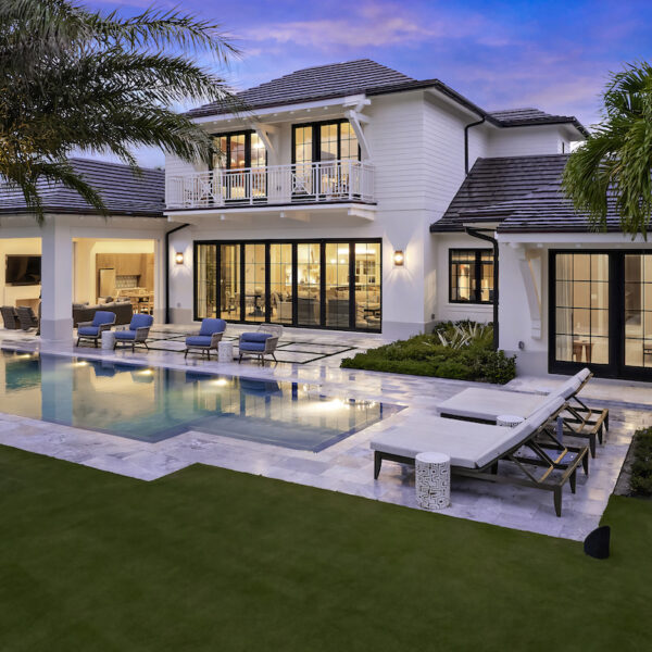 Elegant house featuring pool and palm trees.