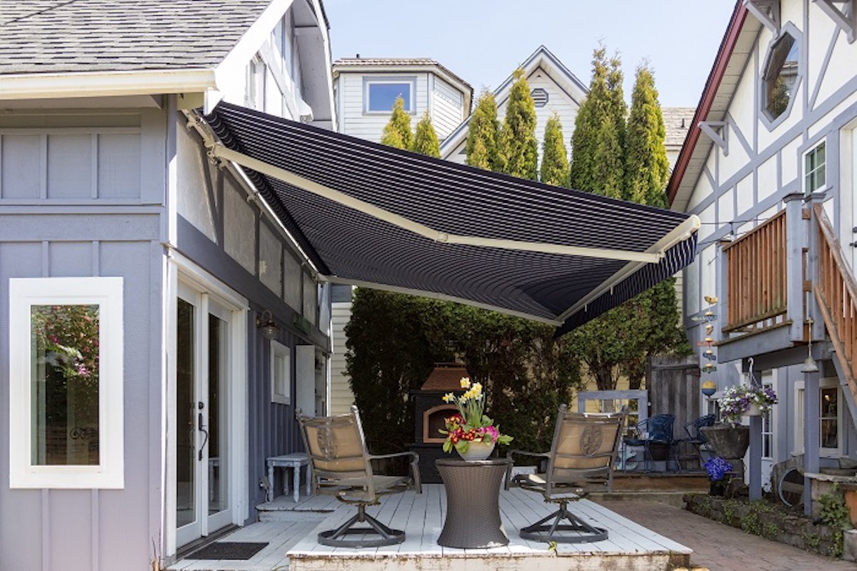 A cozy patio with a shaded awning and comfortable chairs, perfect for relaxing outdoors.