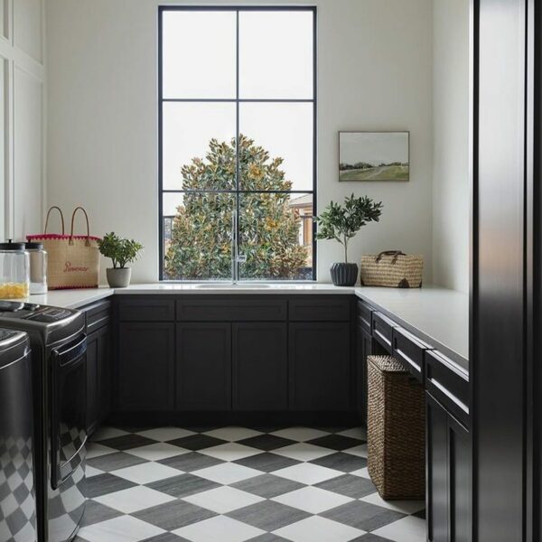 Sleek laundry room design with black cabinets and checkered floor.