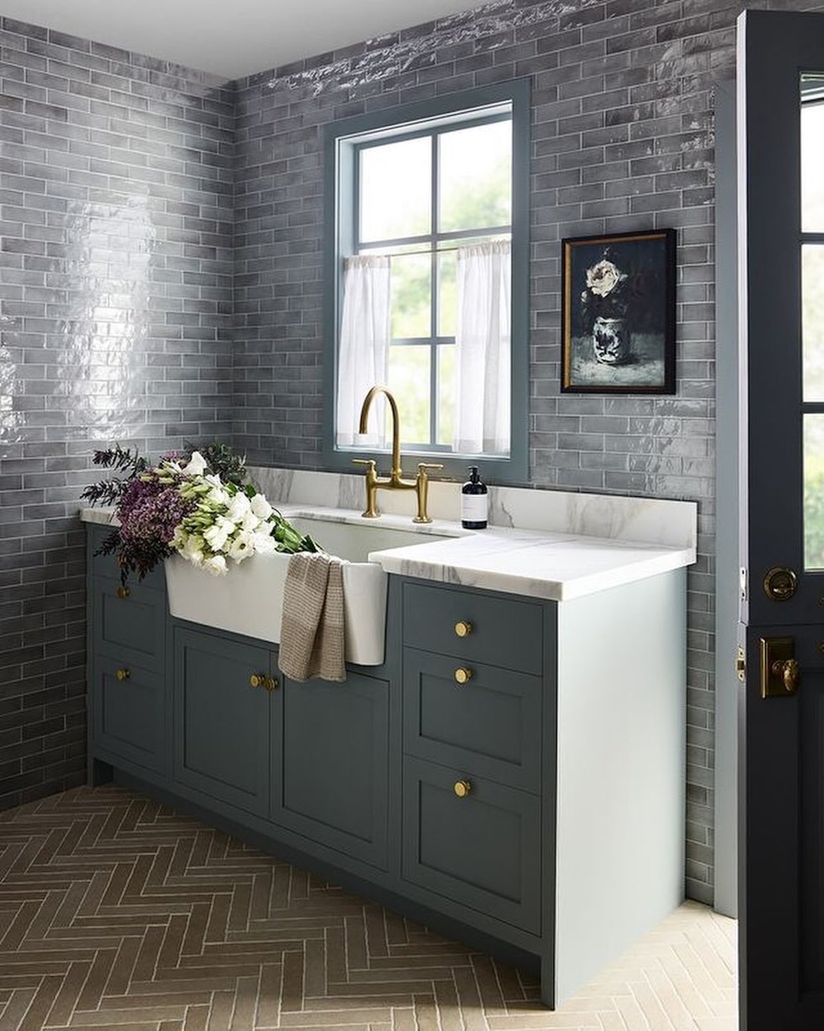 Modern mudroom with a farmhouse sink and gold fixtures.
