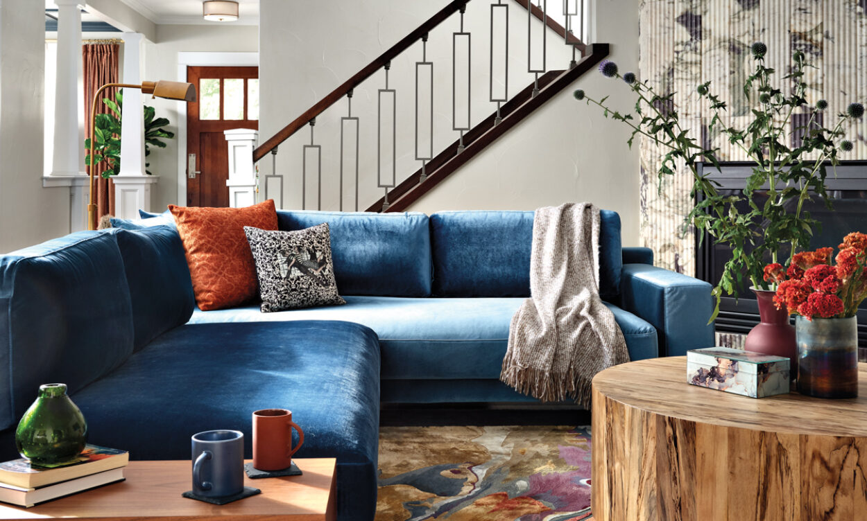 colorful living room with staircase in background and teal blue sectional