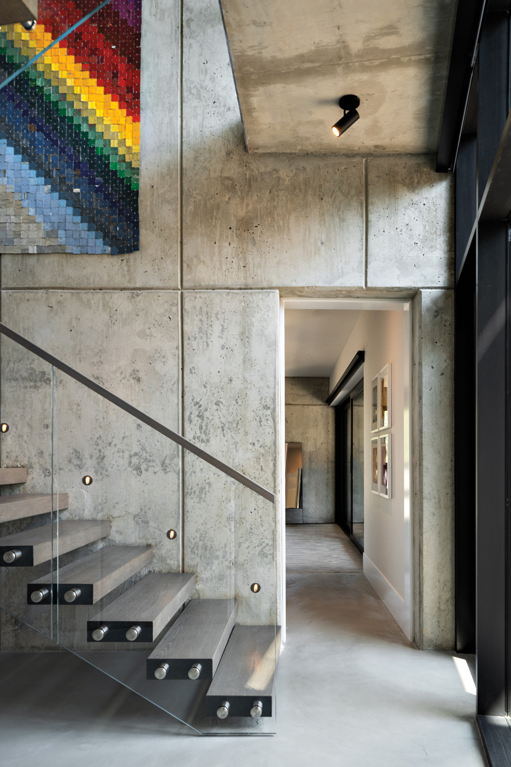 concrete stairwell with floating wooden...