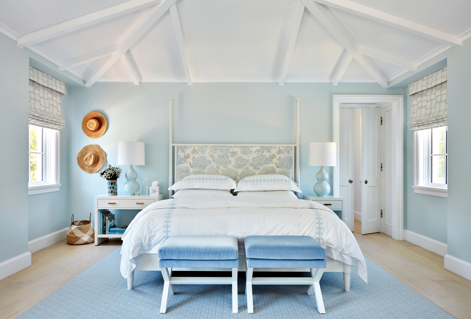Bedroom with soft blue color palette featuring a pitched ceiling.