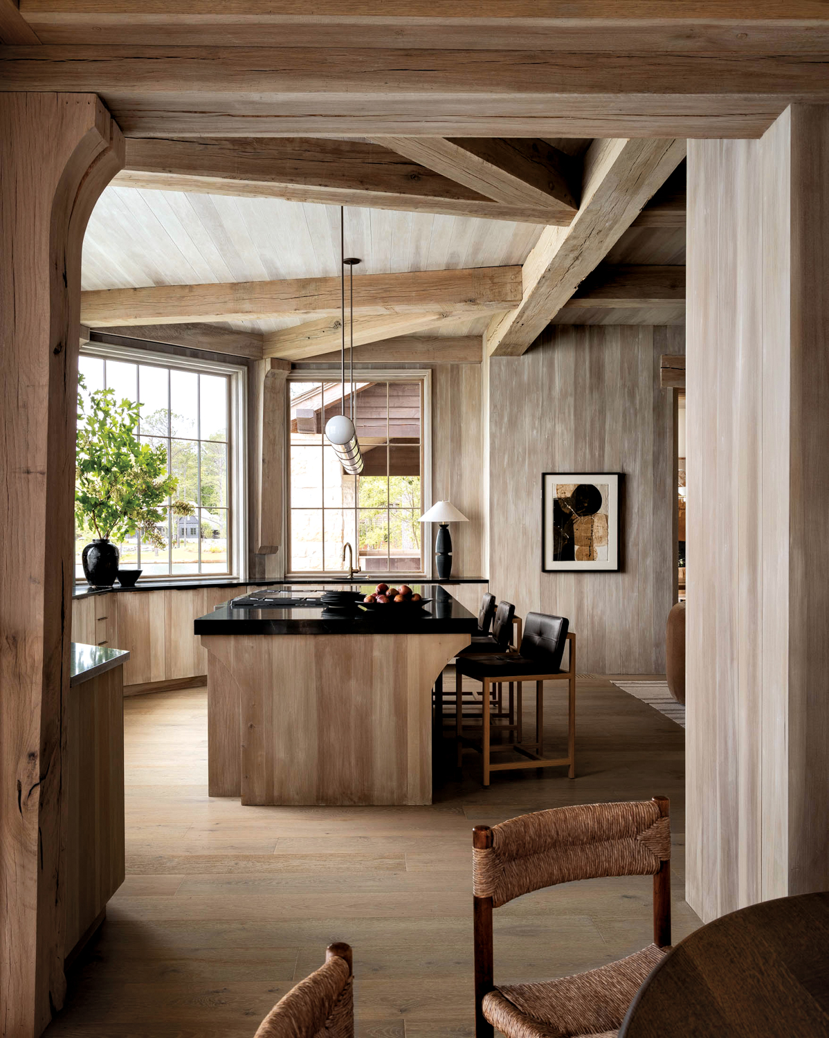 Light wood floors, walls and beamed ceilings in an open layout kitchen