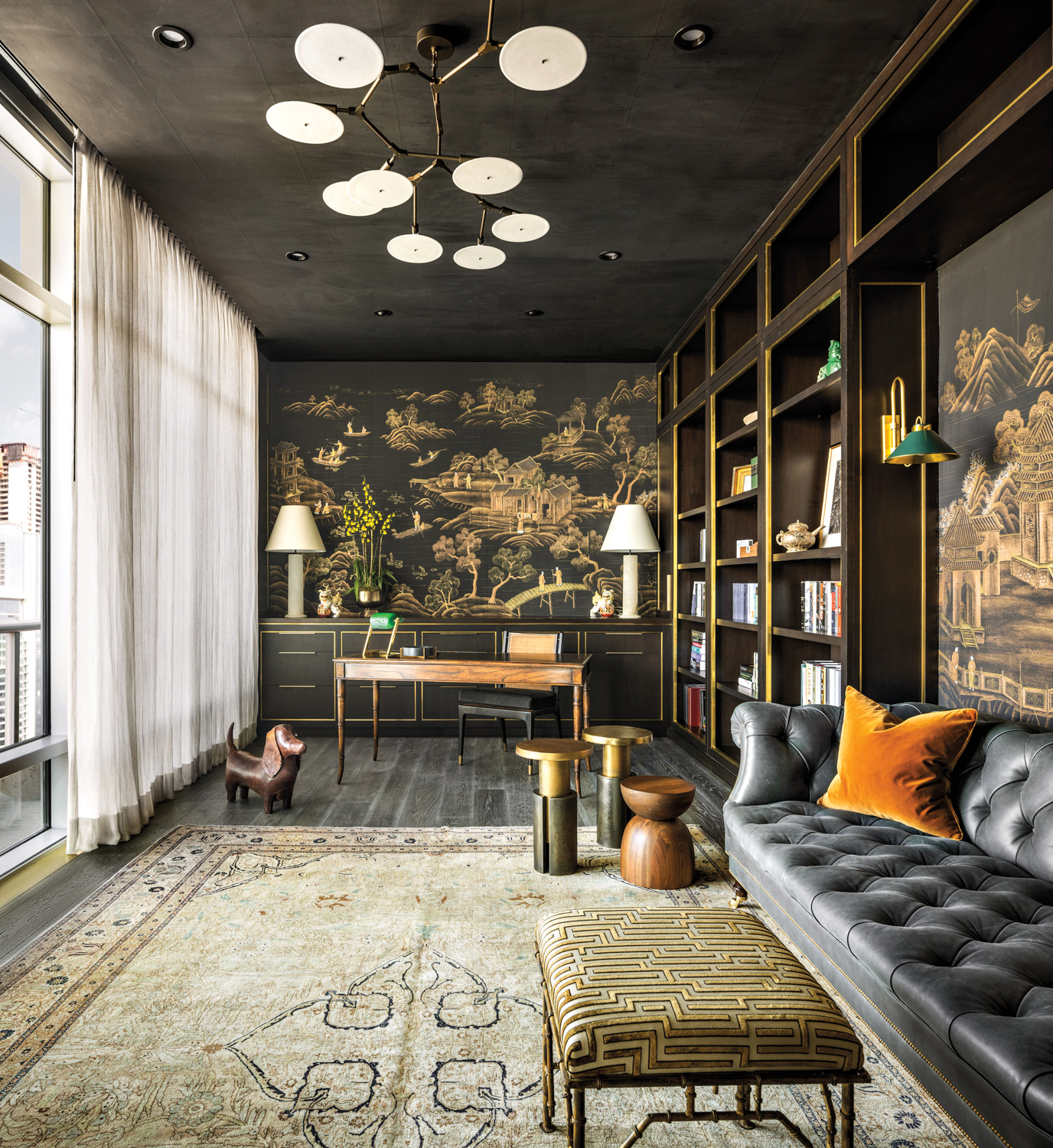 Office and lounge space with muted black ceiling and Asian-influenced painted murals on the walls