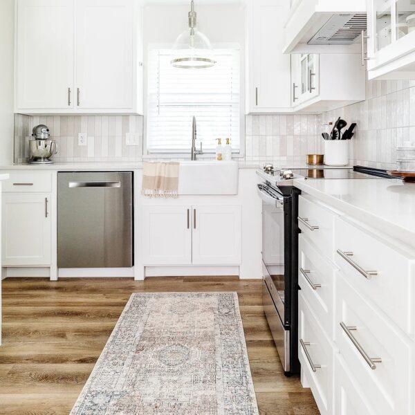 a kitchen with white cabinets and a rug