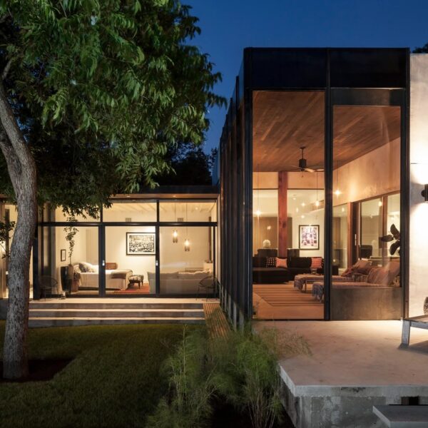 a house with glass walls and a tree