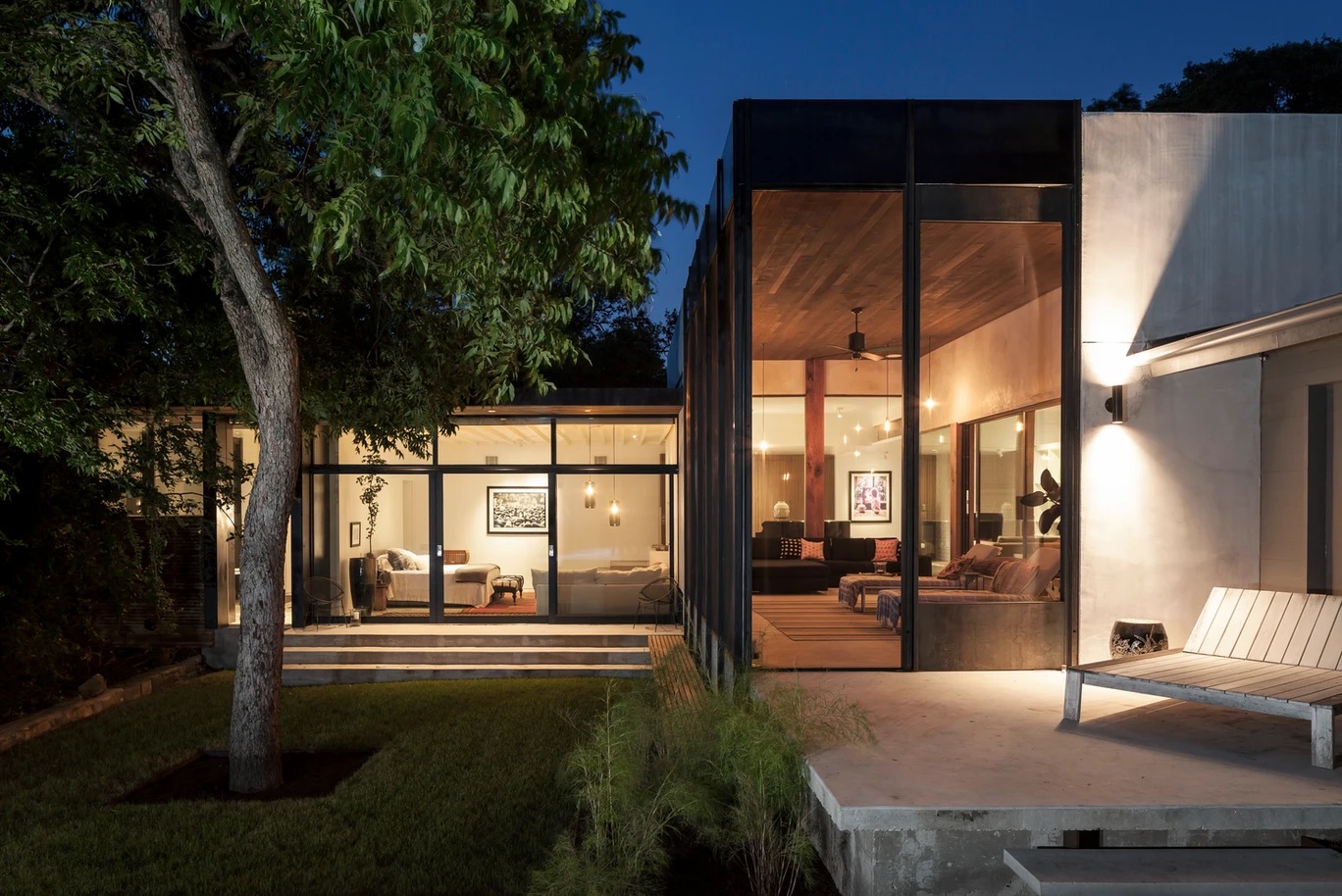 a house with glass walls and a tree