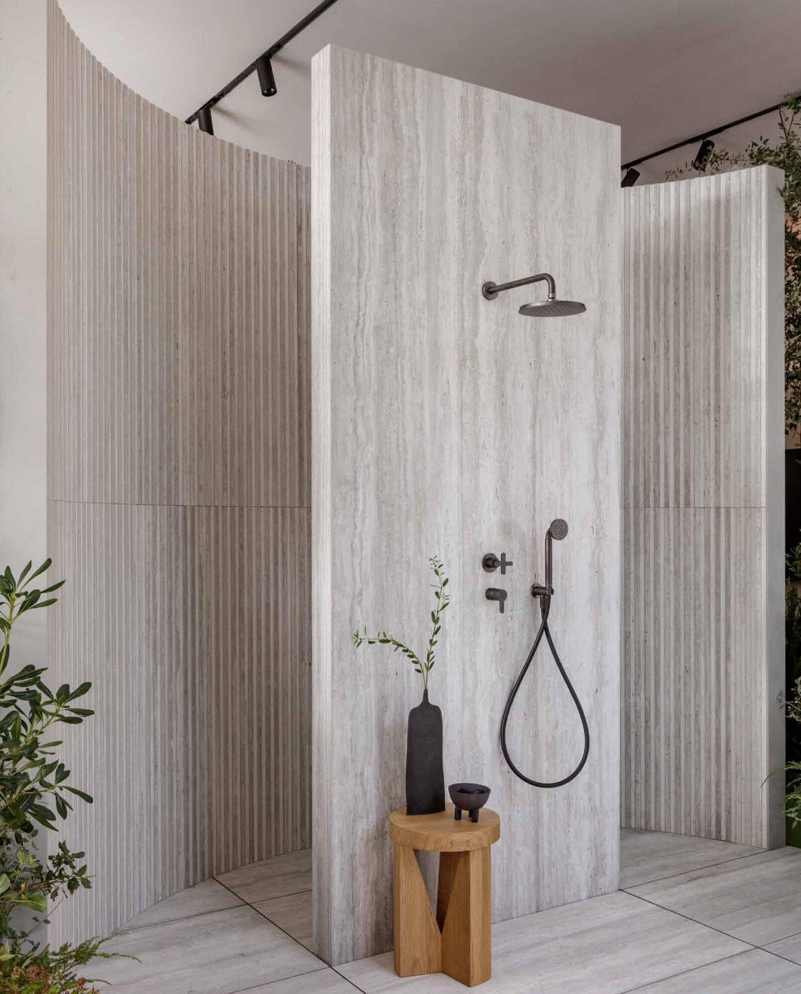 a shower with a rope and a vase on a stool