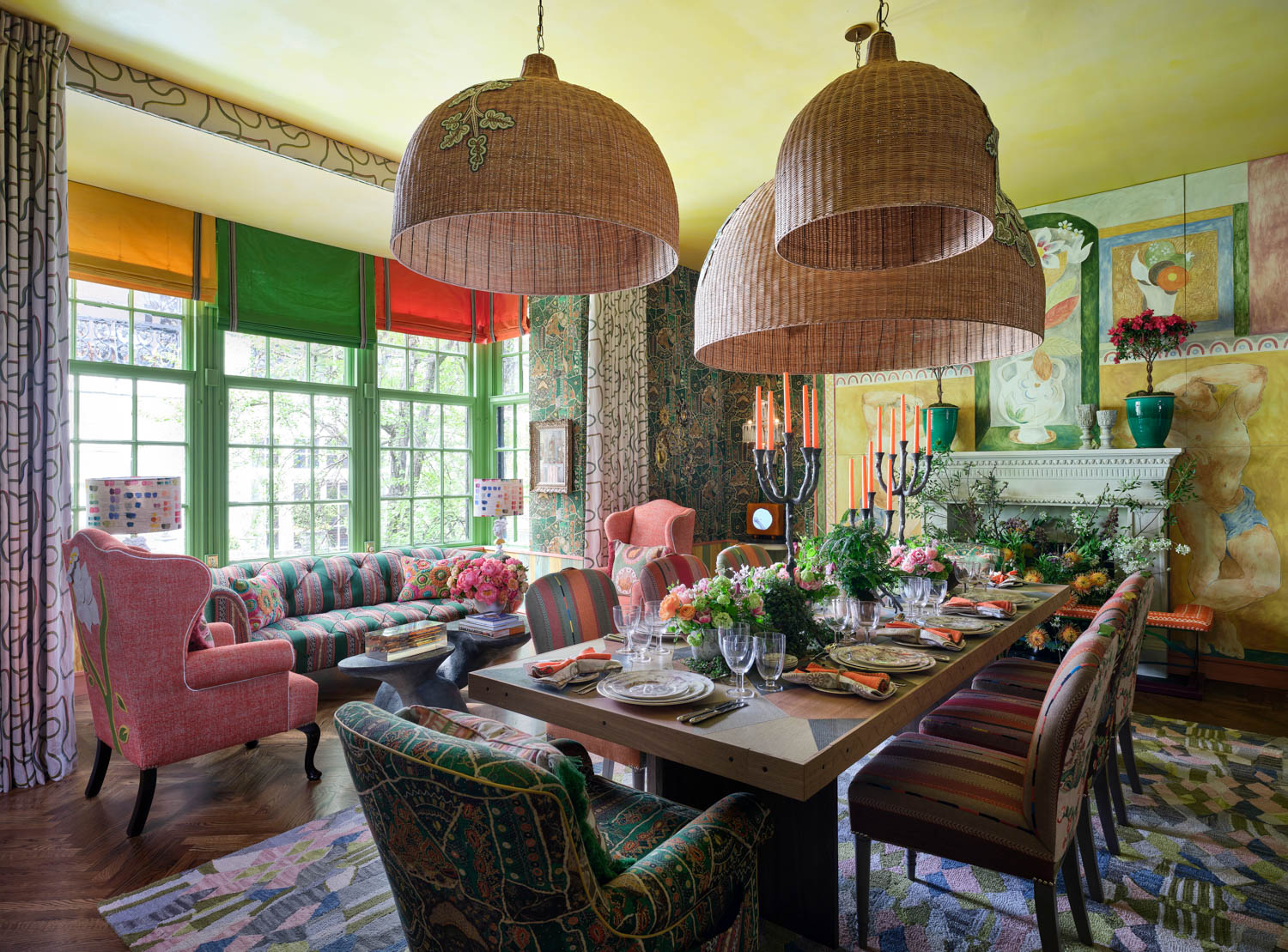 woven shades hang over the dining table in this colorful room