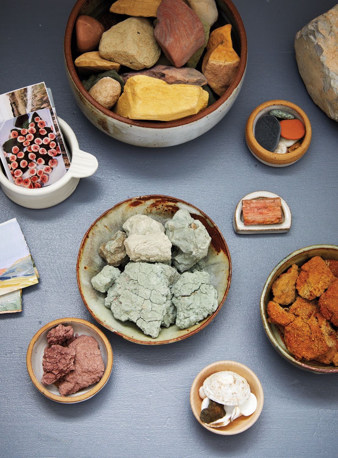 collection of various colored rocks in bowls on a table