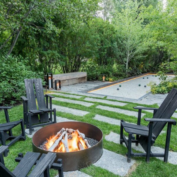 A cozy backyard with a fire pit surrounded by chairs, perfect for gathering and enjoying outdoor evenings.