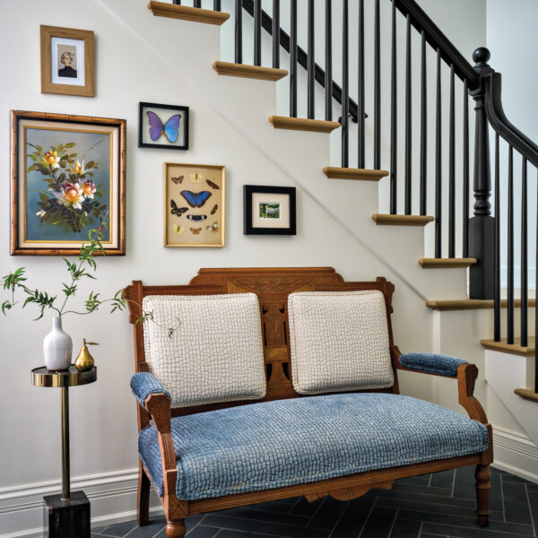 antique settee and side table beneath a gallery wall along the staircase