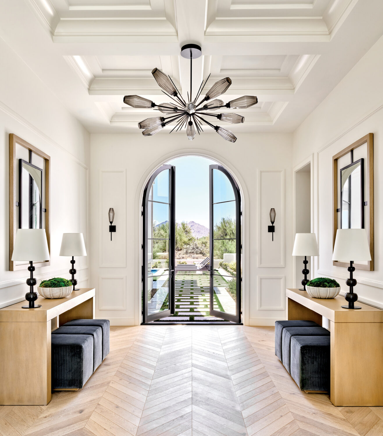 foyer with chevron white oak flooring beneath an Art Deco style chandelier