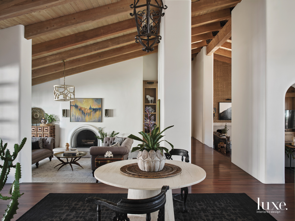 A black rug and white center table add a modern touch to the traditional touches in the entryway.