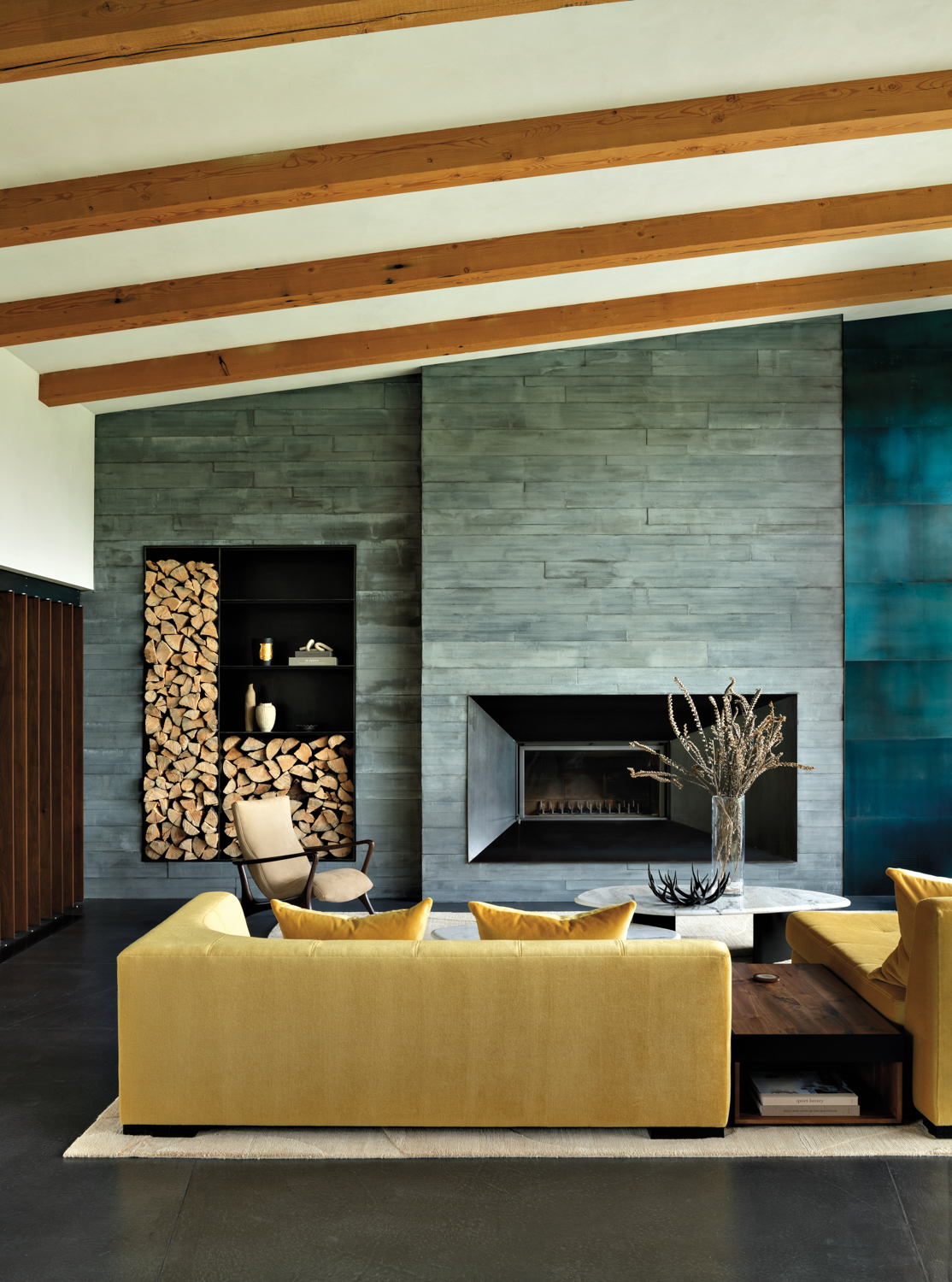 modern living room with a concrete fireplace wall and yellow sofa