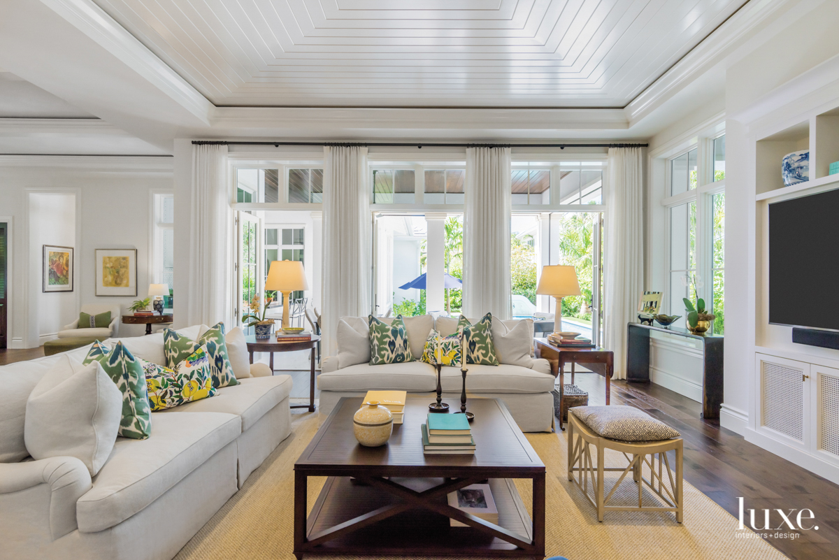 living room with two sectionals, tongue-and-groove wood-plank ceiling and a tan rug