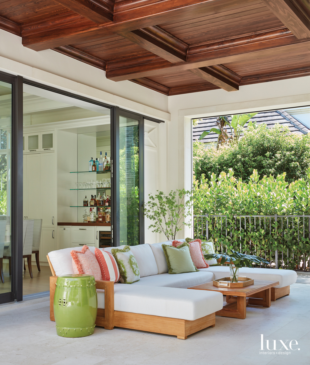outdoor living area with teak RH sectional and citrus pillows