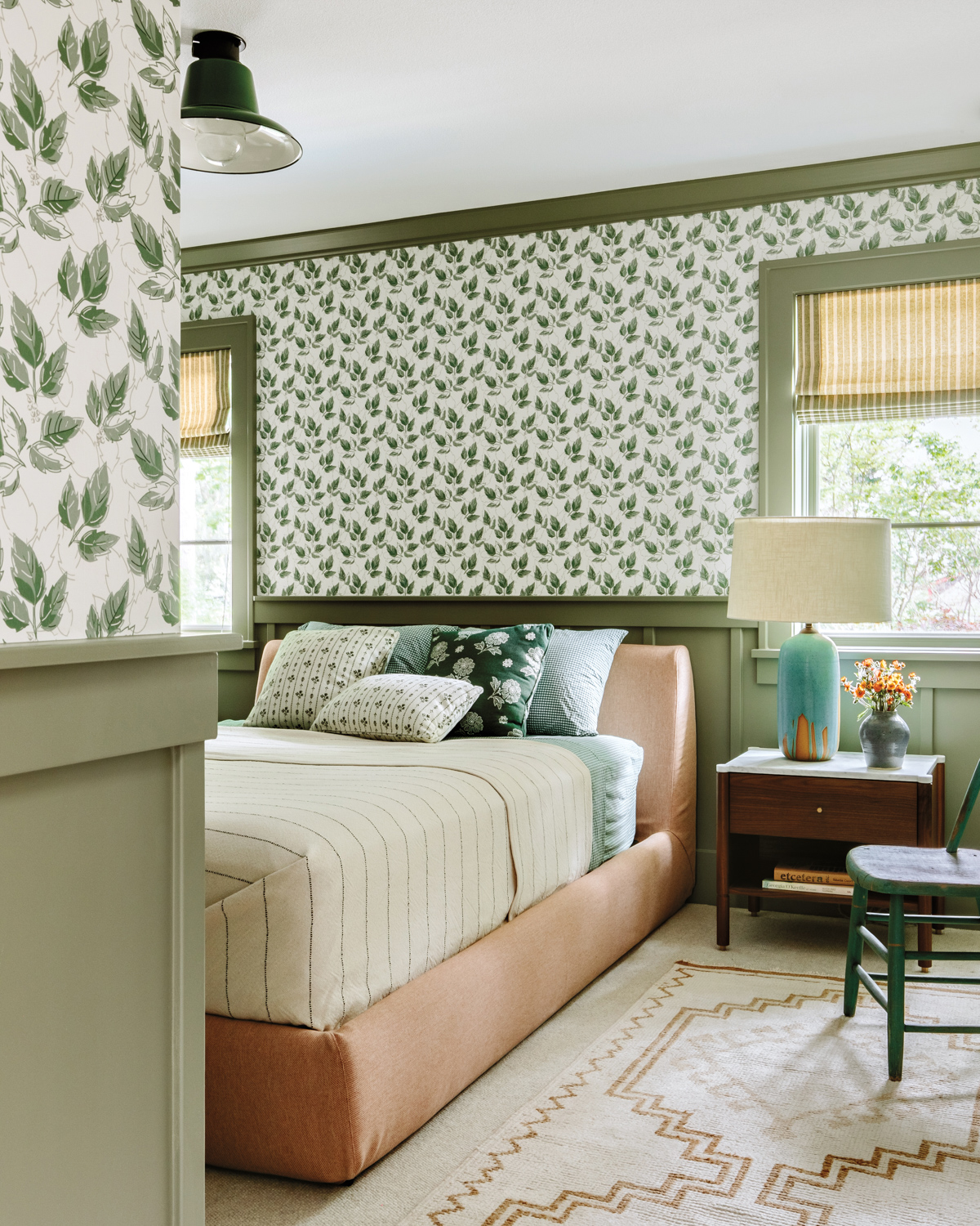cozy guest room with white and green wallpaper and green batten board