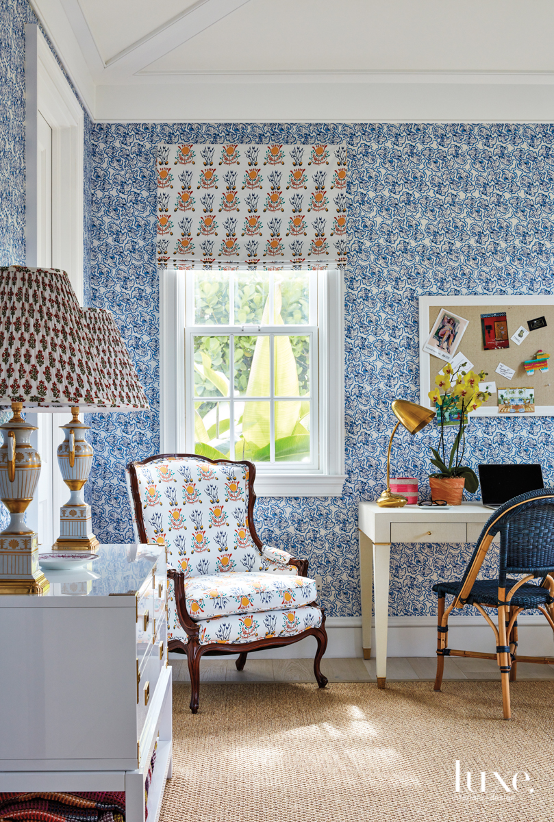 The wife's office shows off Skok's Brimfield wallpaper in Delft Blue from Monica James; her Emmie fabric in the Multi colorway appears on the valance and antique armchair. Bungalow 5's Tansu console table, holding vintage lamps acquired in London, and Claudette desk counter Serena & Lily's Sunwashed Riviera chair on a Fibreworks rug.