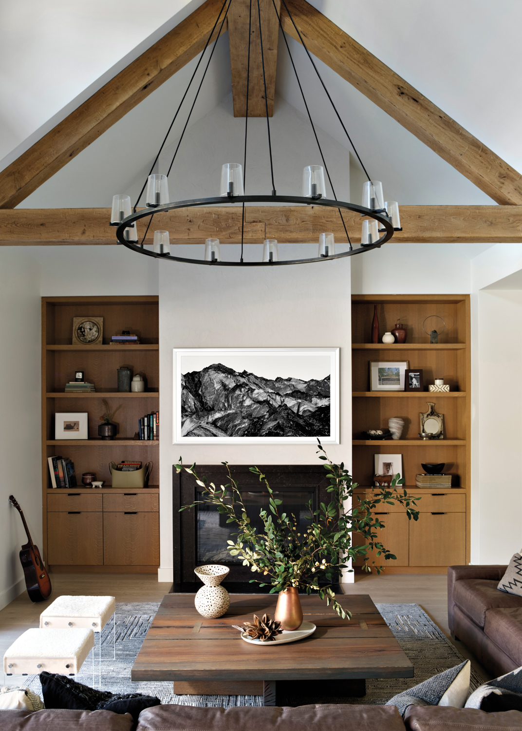 sofa and wooden coffee table under chandelier and vintage photograph in living room by Sondra Ganz