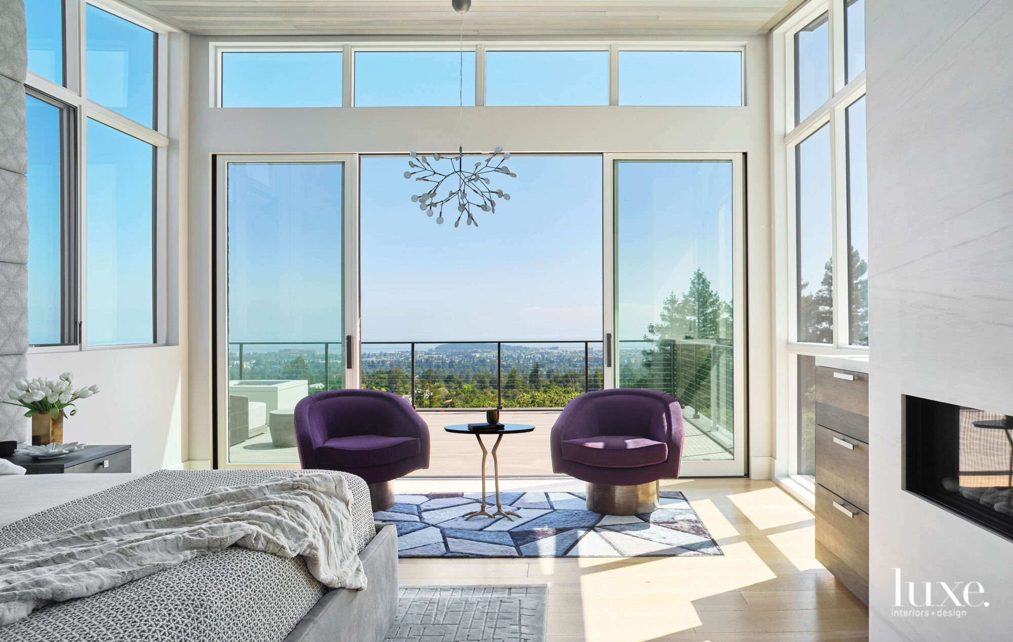 Two purple chairs sit in front of an oversize window.