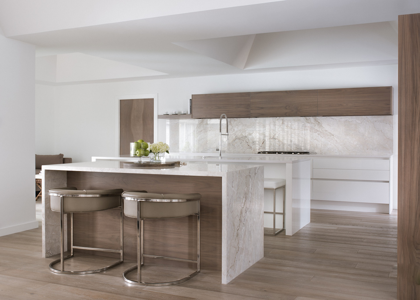 Seamless blend of warm wood cabinetry and softly veined stone surfaces. Clean lines