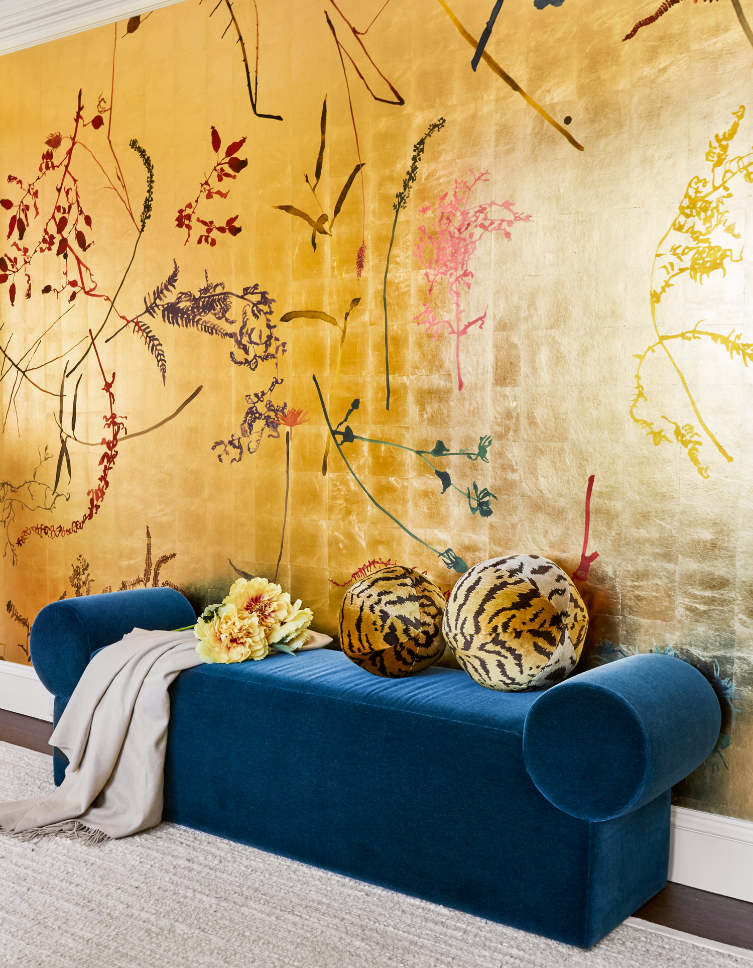 home office with gold wallpaper and blue couch