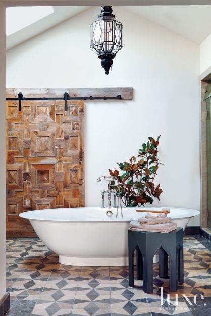 decorative pine plank barn door in bathroom with freestanding white tub